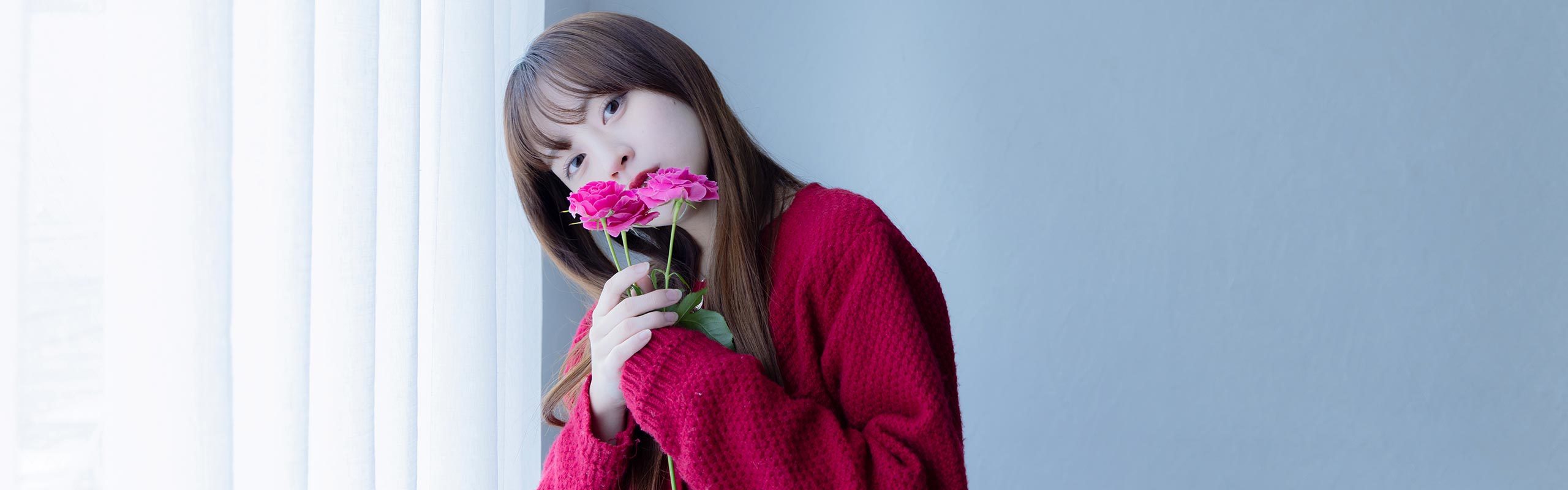 ピンク色の花を両手で持つ中川さん。