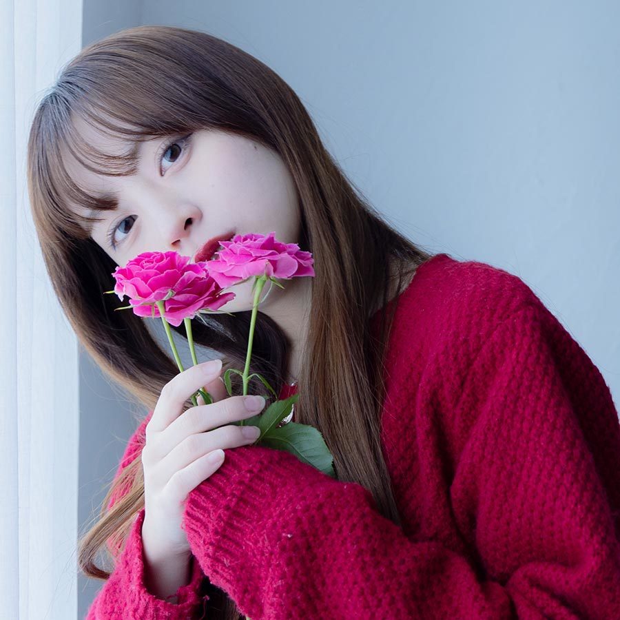 ピンク色の花を両手で持つ中川さん。