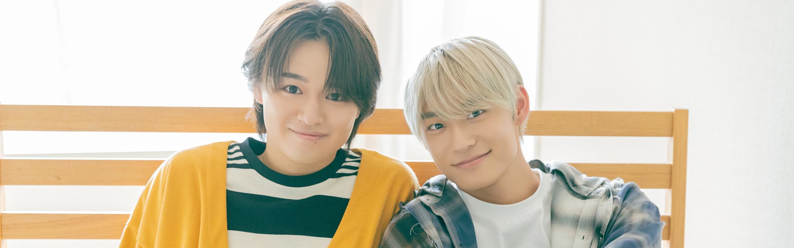 ベッドに座りこちらを見つめる髙松アロハさんと大倉空人さん。