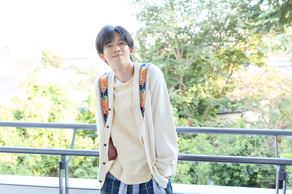 ベランダにて微笑むリョウガさん。