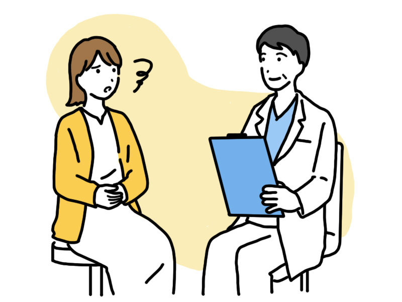 白衣を着た医師にガスだまりの症状を相談する女性。