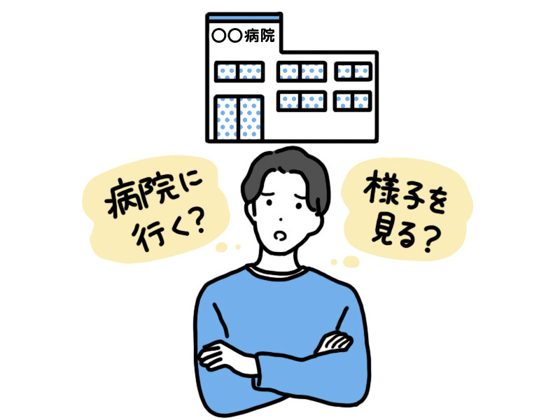 腕を組んで「病院に行く？ 様子を見る？」と悩む男性。