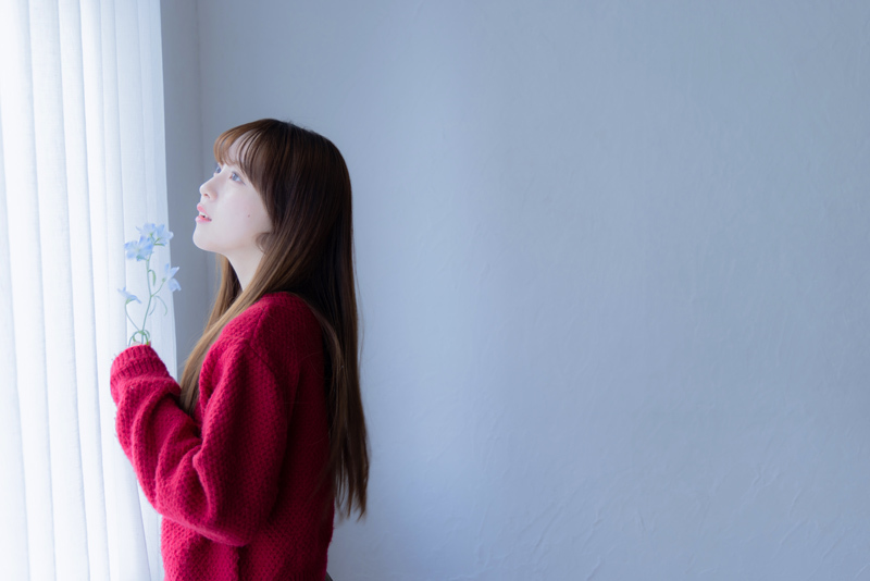 花を持って窓を見る中川さん。