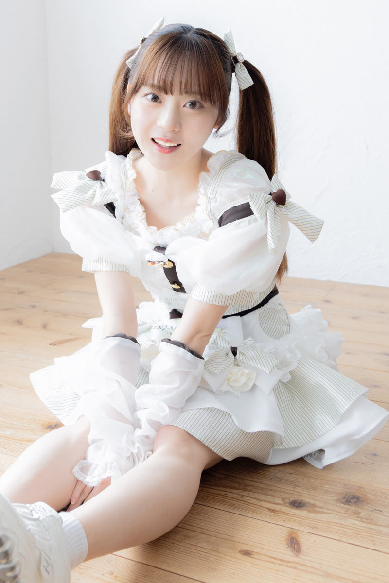 ステージ衣装で床に座る中川さん。