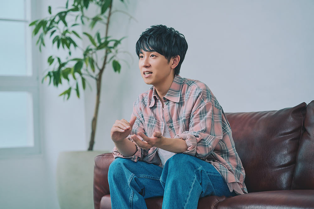 ソファに座って身ぶりを交えて 話す山下さん。