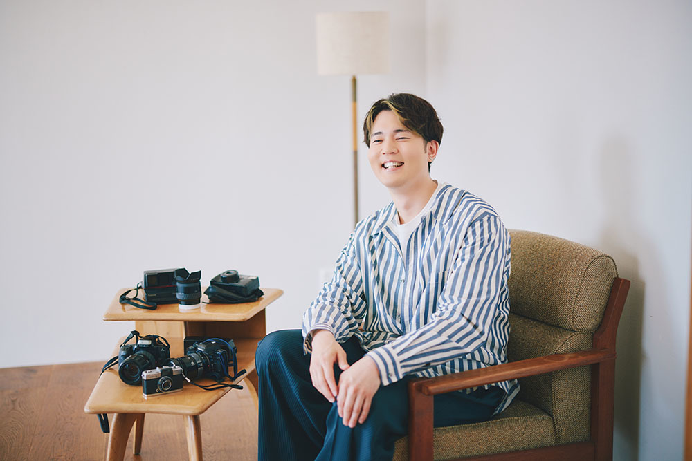 カメラの横で笑う駒田さん。