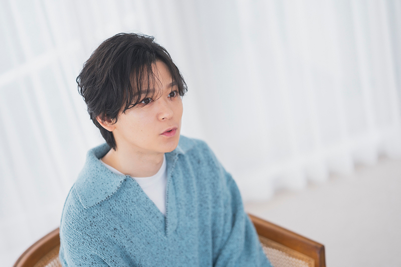 椅子に座って話す土岐さん。