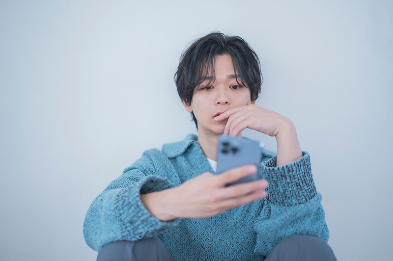 iPhone 13 Proを操作をする土岐さん。