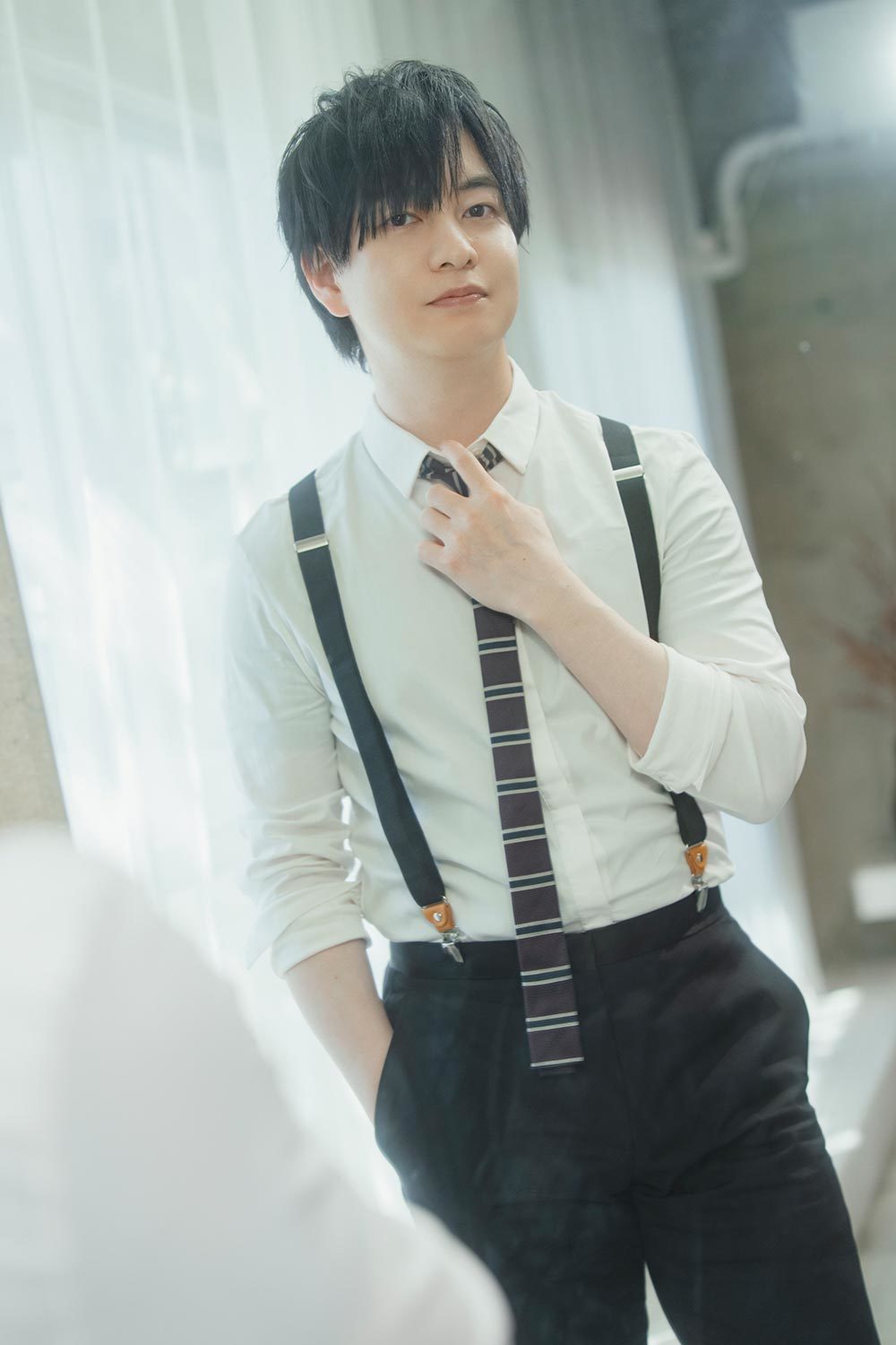 鏡でネクタイを直す声優の小林さん。