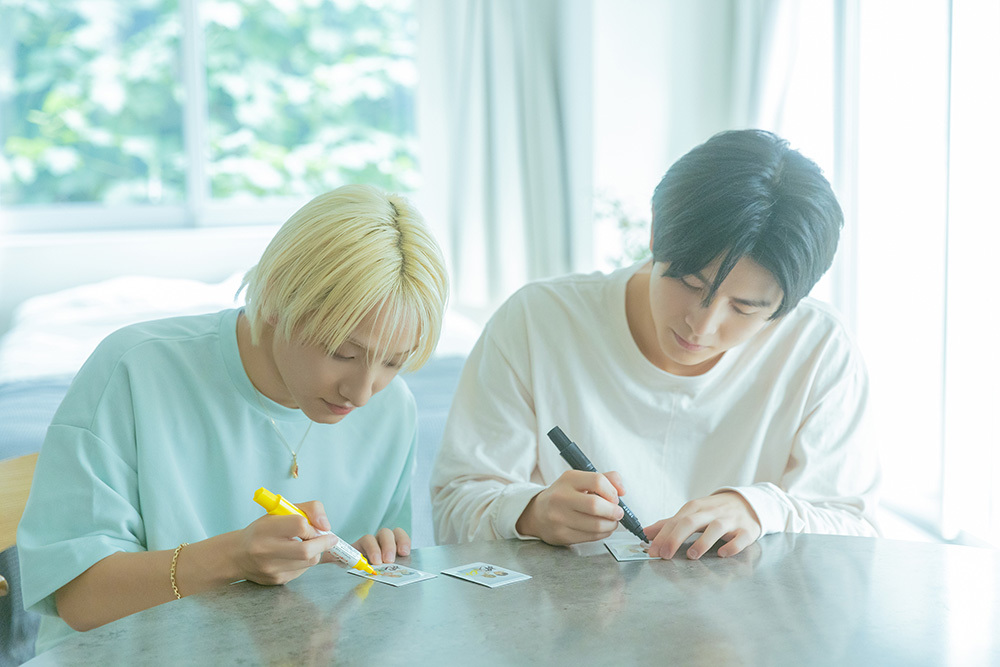 チェキにサインをするハルさんとFUMIYAさん。