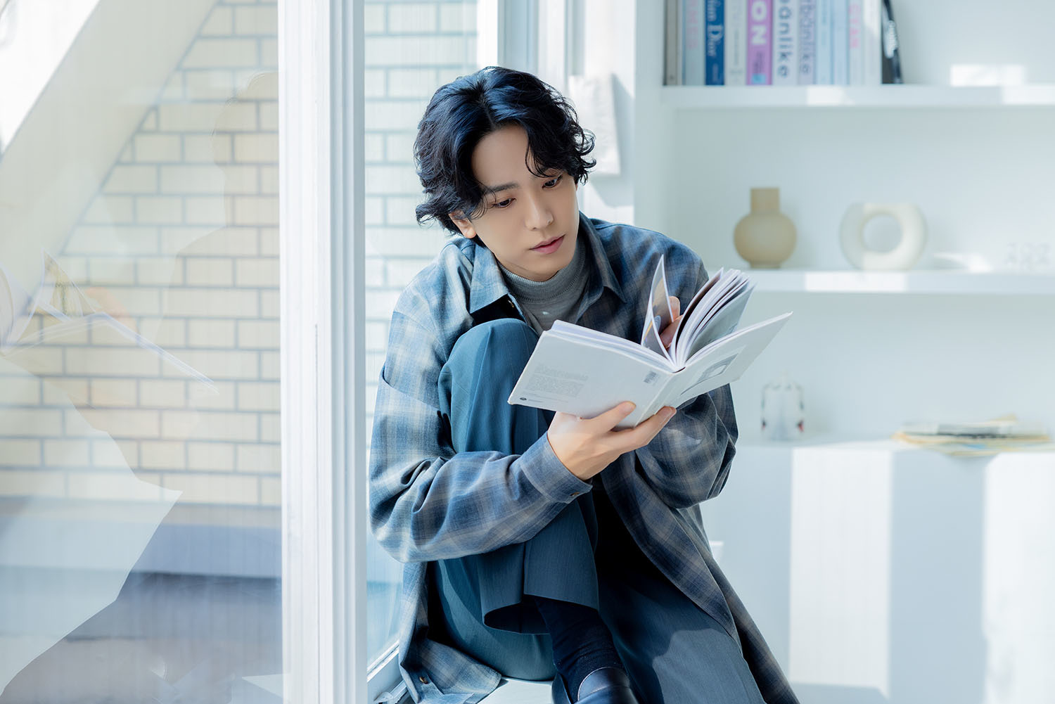 窓辺で本を読む黒羽さん。