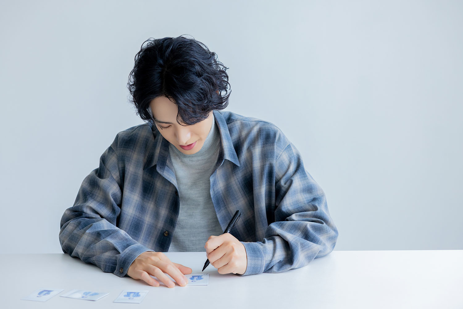 チェキにサインをする黒羽さん。