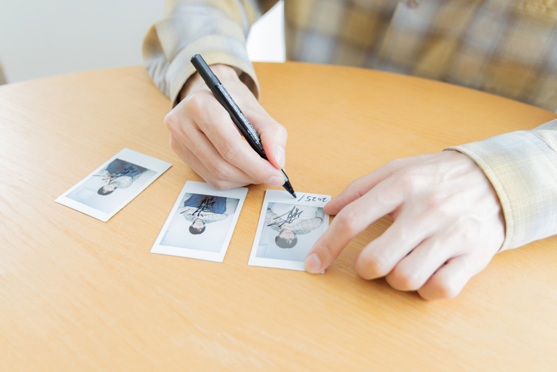 チェキにサインをする和田さん。